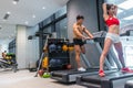 Active Asian Chinese people man and woman personal trainer on running tread mill doing exercise workout in indoor gym. People and