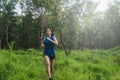 Active Asian woman running in tropical green forest trail Royalty Free Stock Photo