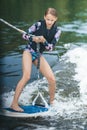 Active beautiful girl in the swimsuit standing on the wakeboard in the river Royalty Free Stock Photo