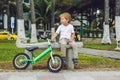 Active blond kid boy and bicycle near the sea. Toddler child dreaming and having fun on warm summer day. outdoors games for childr Royalty Free Stock Photo