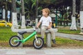 Active blond kid boy and bicycle near the sea. Toddler child dreaming and having fun on warm summer day. outdoors games for childr Royalty Free Stock Photo