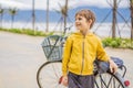 Active blond kid boy driving bicycle in the park near the sea. Toddler child dreaming and having fun on warm summer day Royalty Free Stock Photo