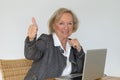 Active blond senior woman showing thumb up