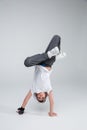 An active boy, dances to break dance, stands on his hands, bending both legs in his lap. Royalty Free Stock Photo