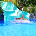 Active boy enjoying water slide in aquapark Royalty Free Stock Photo