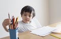 Active boy selecting his favorite pencil colour for painting, School kid using a pencils drawing on white paper, child relaxing at Royalty Free Stock Photo