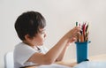 Active boy selecting his favorite pencil colour for painting,School kid using a pencils drawing on white paper, child relaxing at Royalty Free Stock Photo