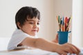 Active boy selecting his favorite pencil colour for painting,School kid using a pencils drawing on white paper, child relaxing at Royalty Free Stock Photo