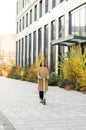 Active businesswoman riding scooter in the city