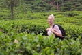 Active caucasian blonde woman enjoing fresh air and pristine nature while tracking among tea plantaitons near Ella, Sri