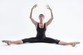 Active Caucasian Relaxed Ballerino Dancer Sitting While Practising Stretching Arms and Legs Exercices In Black Sportive Tights in