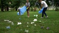 Active citizens collecting garbage in public park, society against pollution