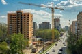 Active construction site with workers, machines, and scaffolding progressing.