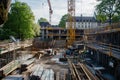 Active construction site with workers, machines, and scaffolding progressing.