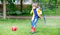 Active cute little kid boy playing soccer and football and having fun Royalty Free Stock Photo