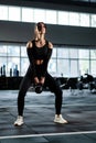 Active dedicated motivated female athlete training in gym with kettle bell, determined confident girl enjoying bodybuilding
