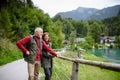 Active elderly couple hiking together in autumn mountains. Senior tourists enjoying view on lake Royalty Free Stock Photo
