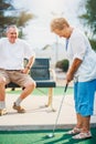 Active elderly senior couple playing miniature golf together Royalty Free Stock Photo