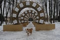 An active and energetic dog runs along a stone path near a Christmas decoration in the form of a clock. The Australian