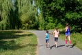 Active family fitness outdoors, running in park, mother and kids exercising and jogging together Royalty Free Stock Photo