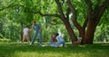 Active family have fun on green park meadow. Parents play with kids outside. Royalty Free Stock Photo