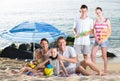 Active family with kids together on beach sitting Royalty Free Stock Photo