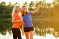 Active family at outdoor. two flexibility curly blonde beautiful woman twin sisters in stylish sportswear have a rest