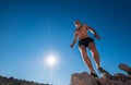 Active fast running mountain sweaty body muscular runner just achieved the cliff summit and enjoying views during the morning Royalty Free Stock Photo