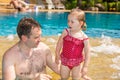 Active father teaching his toddler daughter to swim in pool on tropical resort. Royalty Free Stock Photo