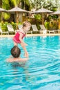 Active father teaching his toddler daughter to swim in pool on tropical resort. Royalty Free Stock Photo