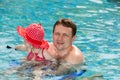 Active father teaching his toddler daughter to swim in pool on tropical resort. Royalty Free Stock Photo