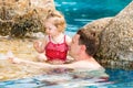 Active father teaching his toddler daughter to swim in pool on tropical resort. Royalty Free Stock Photo