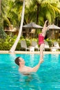 Active father teaching his toddler daughter to swim in pool on tropical resort Royalty Free Stock Photo