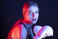 Active Female Boxer Posing in White Gloves And Making Hit Against Dark Background With Colorul Lights Royalty Free Stock Photo