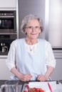 Active female pensioner is preparing strawberries in the kitchen Royalty Free Stock Photo