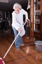 Active female senior is cleaning the floor