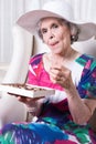 Active female senior earing chocolate candy Royalty Free Stock Photo