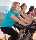 Active females of different age training on exercise bikes Royalty Free Stock Photo