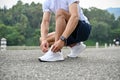 Active and fit Asian athletic man in sportswear tying his running shoe laces. close-up Royalty Free Stock Photo
