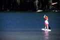 Active fit woman on a Stand up paddle board boating on Todd Lake in the Cascade Lakes area Royalty Free Stock Photo