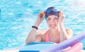 Active senior woman (over age of 50) in sport goggles, cap in swimming pool ready for water aerobics. Royalty Free Stock Photo