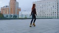 Active ginger woman dancing on rollerblades. Roller skater girl circling at city