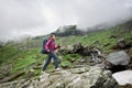 Active girl backpacker climbing uphill in mountains Royalty Free Stock Photo