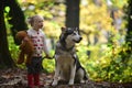 Active girl play with dog in autumn forest. Active rest and child activity on fresh air outdoor