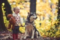 Active girl play with dog in autumn forest. Active rest and child activity on fresh air outdoor