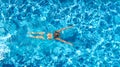 Active girl in swimming pool aerial drone view from above, young woman swims in blue water, tropical vacation