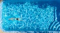 Active girl in swimming pool aerial drone view from above, young woman swims in blue water, tropical vacation