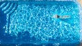 Active girl in swimming pool aerial drone view from above, young woman swims in blue water, tropical vacation