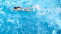 Active girl in swimming pool aerial drone view from above, young woman swims in blue water, tropical vacation, holiday on resort