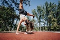 Two athletic women do cartwheels in a sunny park, showcasing their active lifestyle and love for fitness. Royalty Free Stock Photo